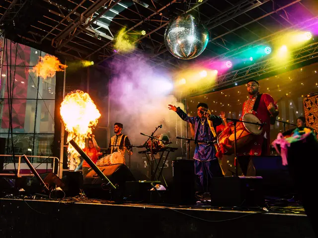Band on stage with flame effects and a mirror ball